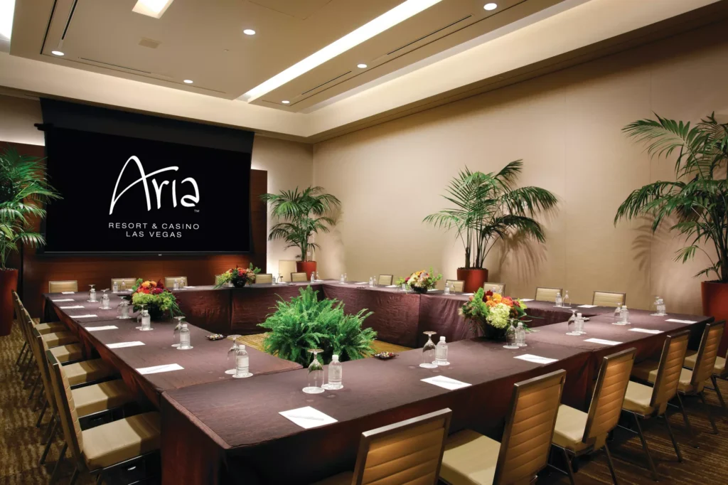 Aria Las Vegas meeting room set for a corporate event with boardroom seating and tropical décor